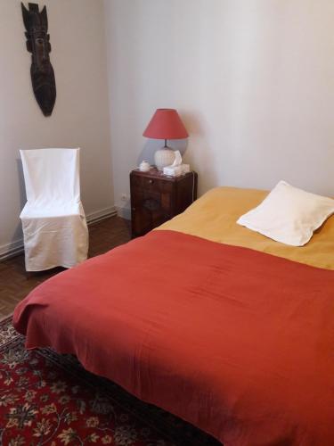 une chambre avec un lit, une chaise et une lampe dans l'établissement Chambre d'hote au Bois du Prince, à Sainte-Croix-aux-Mines