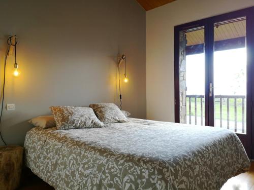 a bedroom with a bed and a large window at Preciosa casa adosada con piscina in Sainte-Léocadie