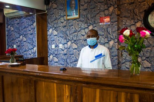 New Hotel Aquiline في أروشا: رجل يرتدي قناع الوجه في البار