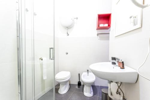 bagno bianco con servizi igienici e lavandino di Arka Apartments a Napoli