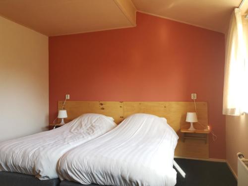 een slaapkamer met een bed met een rode muur bij Mooiplekkie Eext in Eext