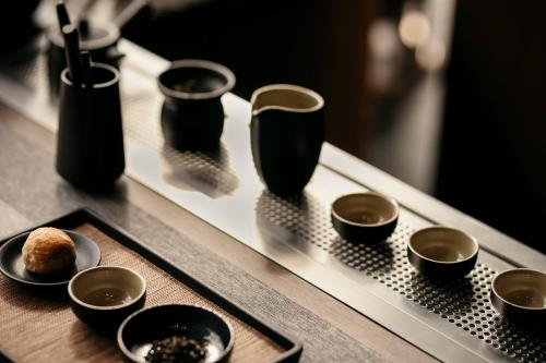 a tray with bowls and cups on a table at The Clan Hotel Singapore by Far East Hospitality in Singapore
