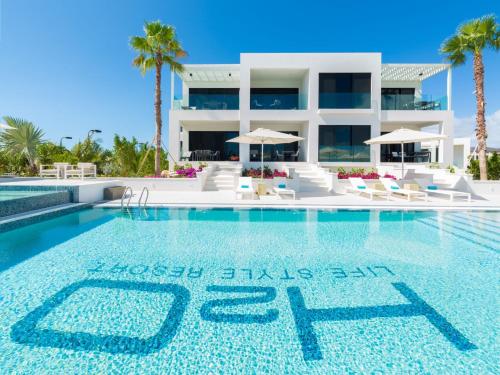 a swimming pool in front of a villa at H2O LifeStyle Resort in Long Bay Hills