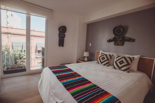 1 dormitorio con 1 cama grande con una cruz en la pared en MyPlace at Santo Domingo, en Ciudad de México