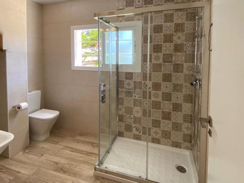 a bathroom with a glass shower with a toilet at Mda Playa del Cantal in Mojácar