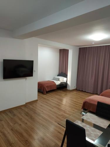 a hotel room with two beds and a flat screen tv at Apartamenty Lawendowy Zakątek 5 in Opole