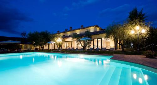 a swimming pool in front of a house at night at Relais dell'Olmo in Perugia