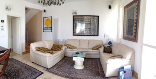 a living room with two couches and a table at Bed & Breakfast Case Osti in Castel Maggiore