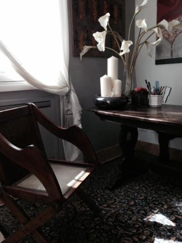 a room with a table and a chair and a table with flowers at Bed & Breakfast Case Osti in Castel Maggiore
