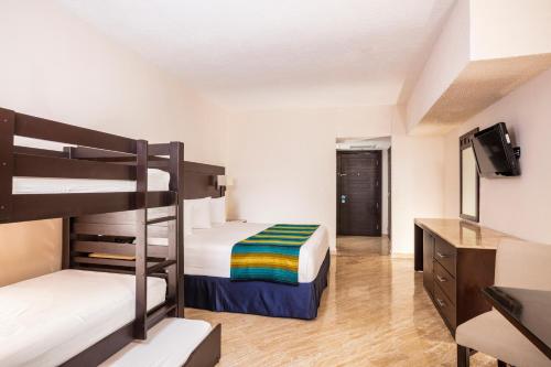 a room with two bunk beds and a television at Crown Paradise Club Cancun - All Inclusive in Cancún