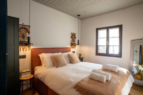 a bedroom with a large bed with two towels on it at Philos Guesthouse in Makrinítsa