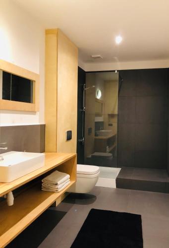 a bathroom with a sink and a toilet and a shower at Barcelona Rooms in Mikoszewo