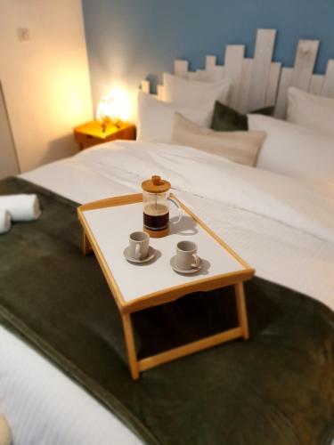 una bandeja con dos tazas en una mesa junto a la cama en Le Guèlèf - Appartement 2 personnes, en Orbey