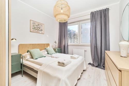 a small bedroom with a bed and a window at Promenady Green Apartments by Renters in Wrocław