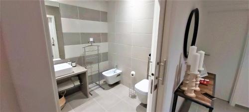 a bathroom with a white toilet and a sink at Albufeira beach apartment in Albufeira