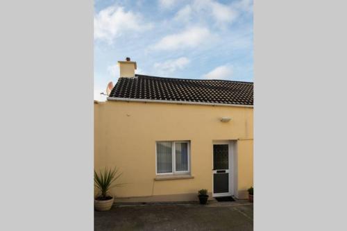 a white house with a black roof at The Chalet town centre in Dungloe