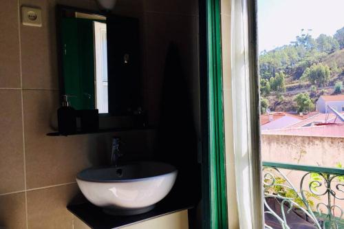 a bathroom with a sink and a window at La Casa Flores, maison traditionnelle portugaise in Odeceixe