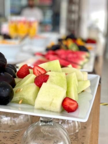 a plate of fruit with strawberries and other fruits at Hotel Zentiva Pinamar in Pinamar