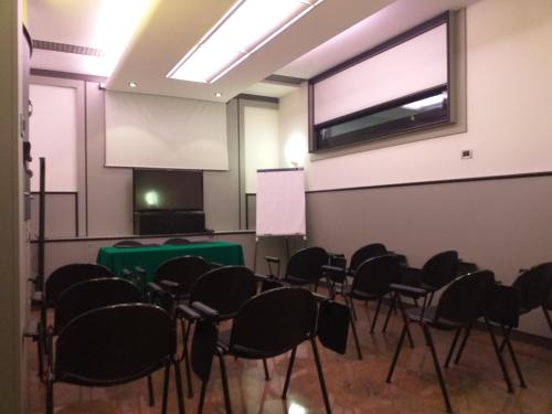 an empty room with chairs and a projection screen at Sure Hotel by Best Western Milano in Padova
