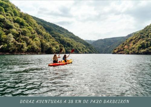people on a raft in the water at Pazo Barbeirón Slow Hotel Ribeira Sacra in Puebla de Trives