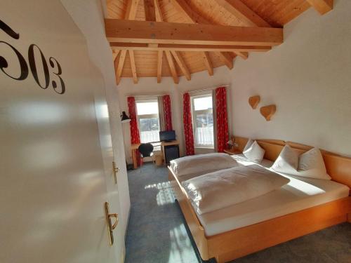 a bedroom with a bed and a desk and windows at Hotel Oberwirt Wangen in Wangen im Allgäu