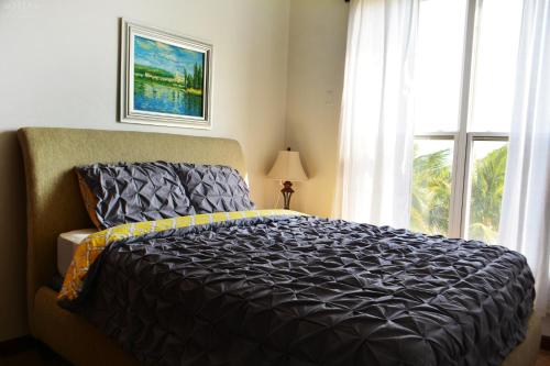 a bedroom with a large bed and a window at Brahma Blue Resort in San Pedro