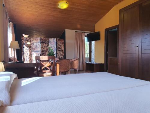 a bedroom with a bed and a desk and a table at HOTEL MASIA EL MOLINETE in Mora de Rubielos