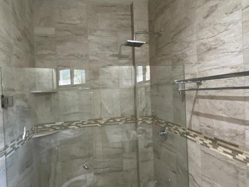 a bathroom with a shower with a glass door at Cuxos Hotel Beachfront in Isla Mujeres