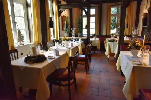 a dining room with tables with white tablecloths at Klosterschänke Hude Hotel Ferienwohnungen Restaurant Café in Hude