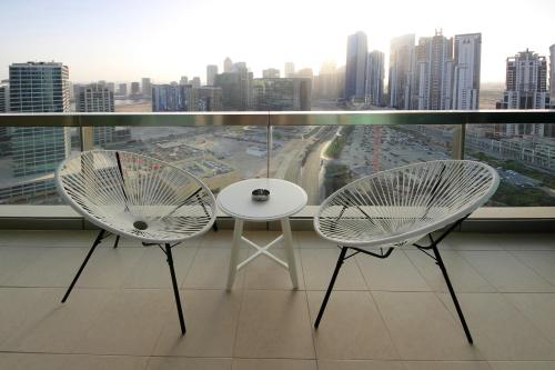 two chairs and a table in front of a window at Prime Retreats - Downtown Dubai in Dubai