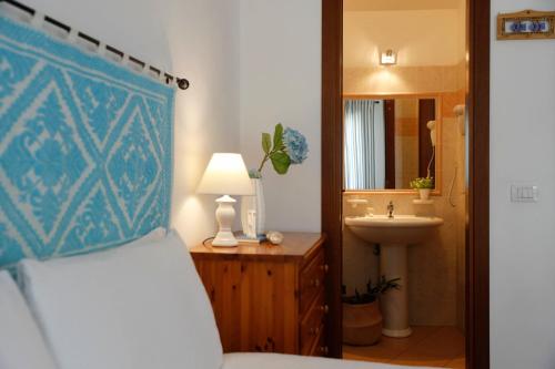 y baño con cama, lavabo y espejo. en Il Melo Residence en Porto Torres