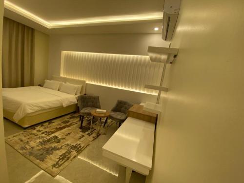 a bedroom with a bed and a table and chairs at فندق المستقبل للشقق الفندقية ALMUSTAQBAL HOTEL Apartments in Ibrā