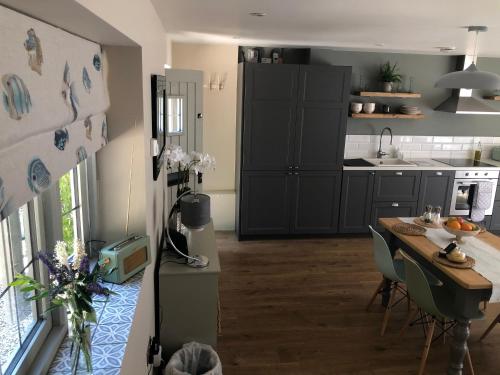 a kitchen with a table and a dining room at Cotswold Lodge in Painswick