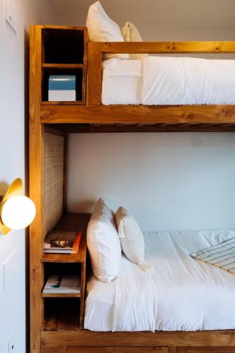two bunk beds with white pillows and a table at The Rockaway Hotel in Queens