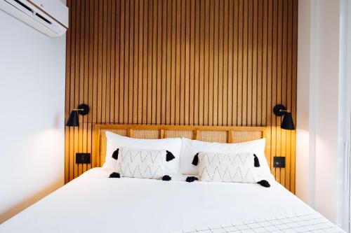 a bedroom with a white bed with a wooden headboard at The Rockaway Hotel in Queens
