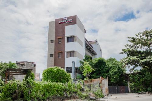 um edifício branco alto com um cartaz em Cornerstone Manor Inn em Talamban Viejo