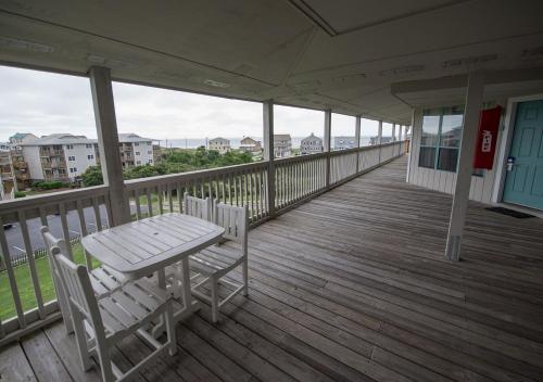 a porch with a table and chairs on a balcony at Atlantic Beach Resort, a Ramada by Wyndham in Atlantic Beach