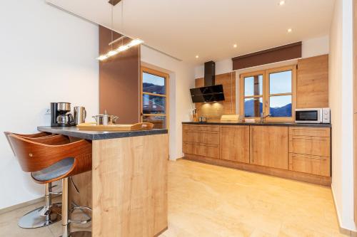 a kitchen with wooden cabinets and a counter top at Chiemgauferienwohnungen - Maier in Unterwössen