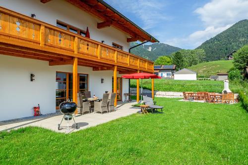 a backyard with a grill and a house at Chiemgauferienwohnungen - Maier in Unterwössen