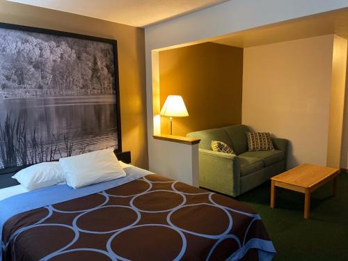 een hotelkamer met een bed en een stoel bij AmeriVu Inn and Suites Shawano WI in Shawano
