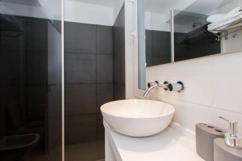 a bathroom with a white sink and a shower at Temporales Ushuaia - Bahia loft in Ushuaia