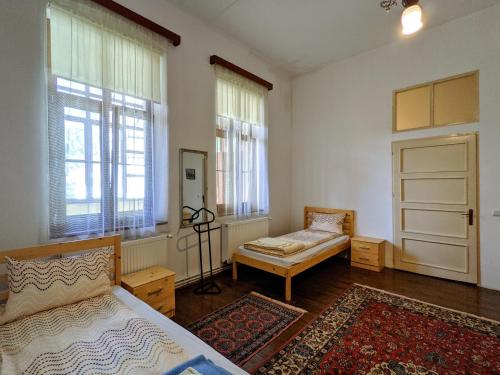a bedroom with a bed and a door and windows at Gästehaus Honigberg next to the Fortified Church of Harman in Hărman