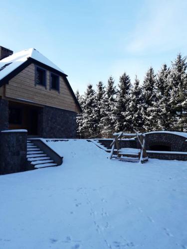 a yard covered in snow next to a house at Lawendowe Siedlisko in Suwałki