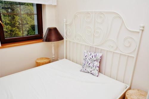 a white bed with a white headboard and a pillow at Lawendowe Siedlisko in Suwałki