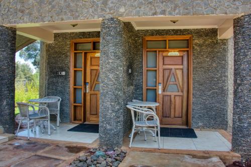 a house with two chairs and a wooden door at Aberdare Prestige & Royal Cottages in Nanyuki