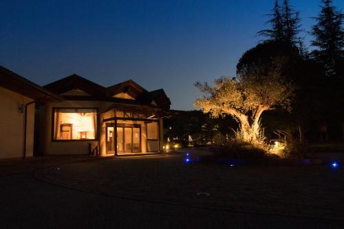 a house lit up at night with a tree at Hotel Le Grotte in Genga