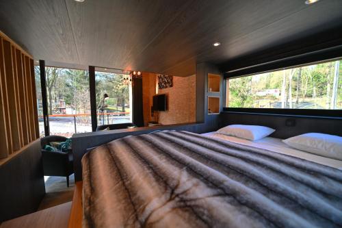 a bedroom with a large bed with a large window at Wild Cube in Durbuy