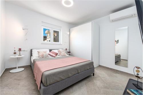 - une chambre blanche avec un lit et une table dans l'établissement Apartments Villa Poco Loco, à Mlini