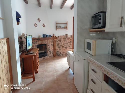 a kitchen with a stove and a fireplace at Casa Rural Los Pinos n5 de Riópar. in Riópar