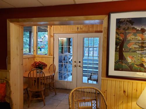 a dining room with a table and chairs and windows at Shambhala Bed and Breakfast in Buckhorn